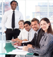 Happy business leader with his team in a meeting looking at the camera photo
